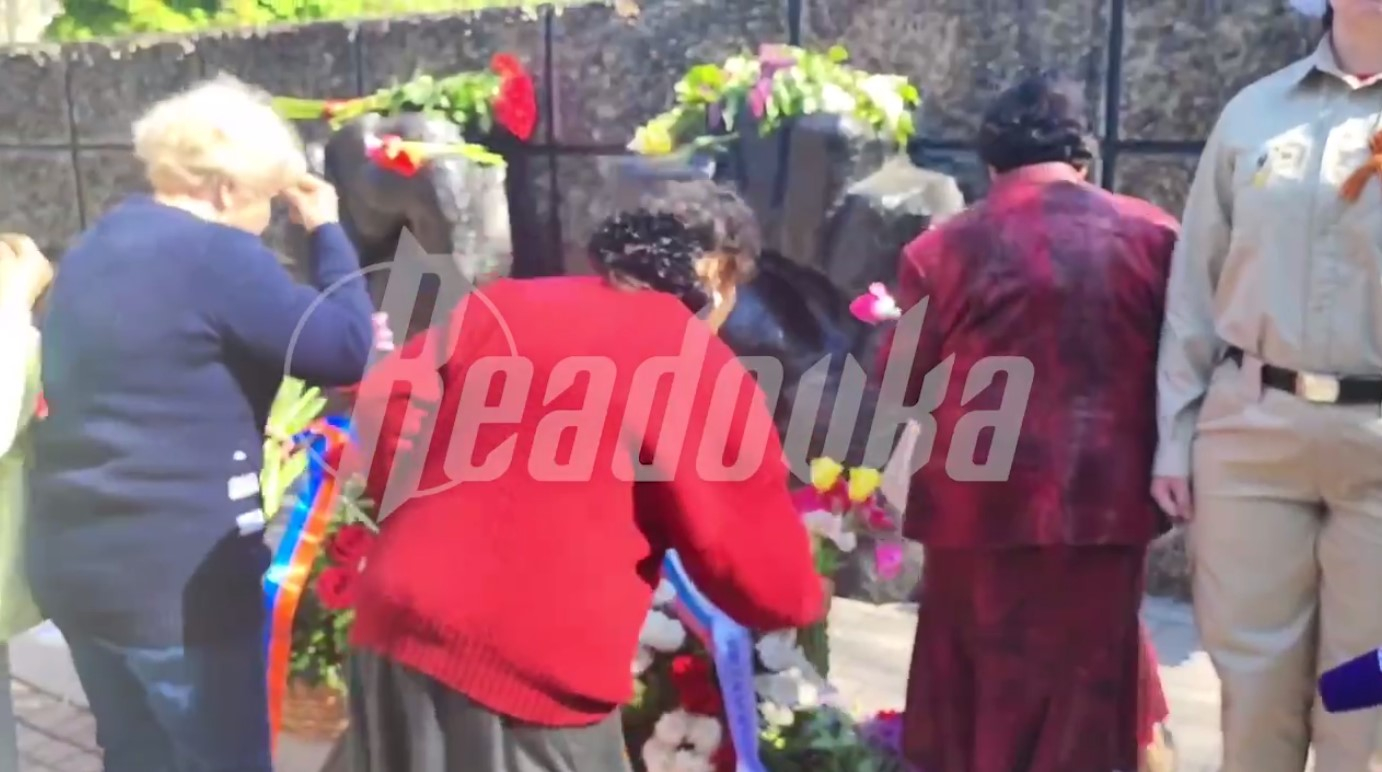 В Мариуполе женщины крестятся перед мемориалом памяти жертв фашизма